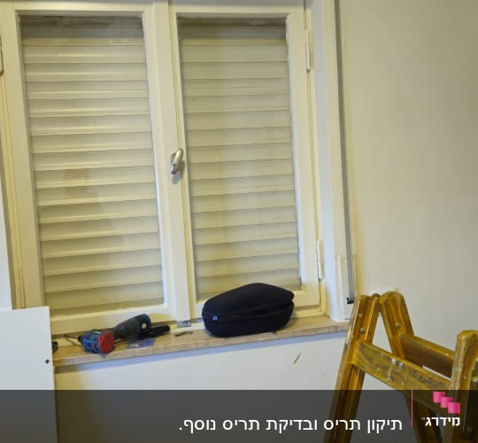 חלון עם תריסים, סולם וכלי עבודה